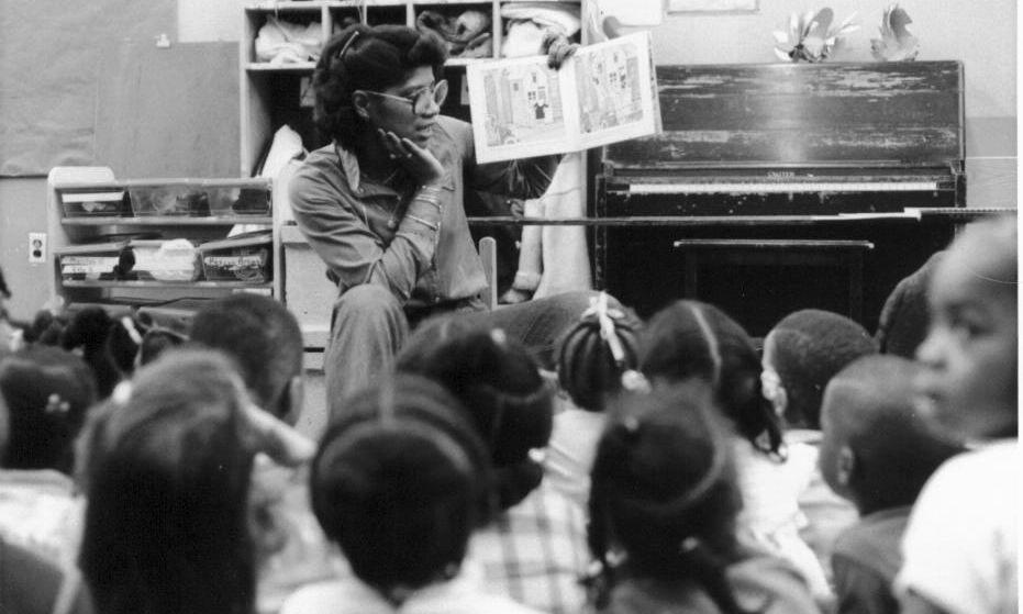 Jesuit Volunteer 1979 reads to students while teaching at their JV placement site in Newark.