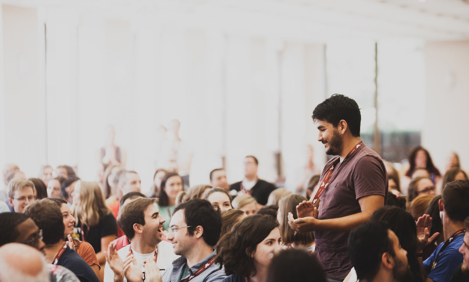 Jesuit Volunteers stand up at 2018 Orientation at Loyola University Chicago when their community house names are called out in celebration of the year ahead. (2018)