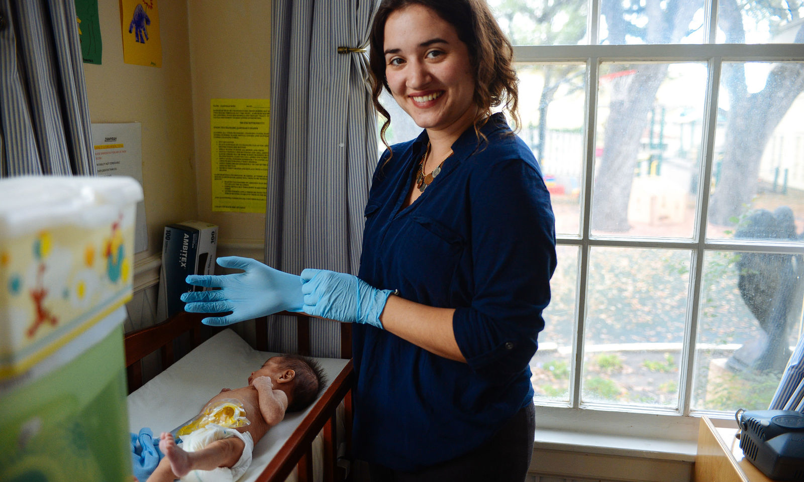 Jesuit Volunteer serving in San Antonio, Texas nursing a baby at their placement site