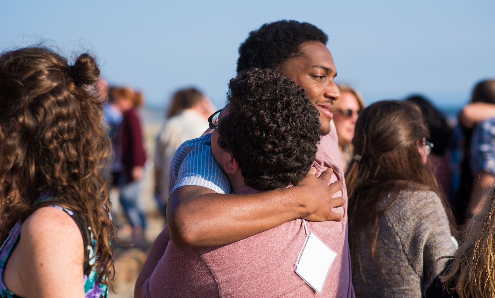 Nico Moore and Taylor Caron - Casa Martin Luther King Jr., San Francisco, CA embrace in a sign of peace at commissioning mass. (2017)